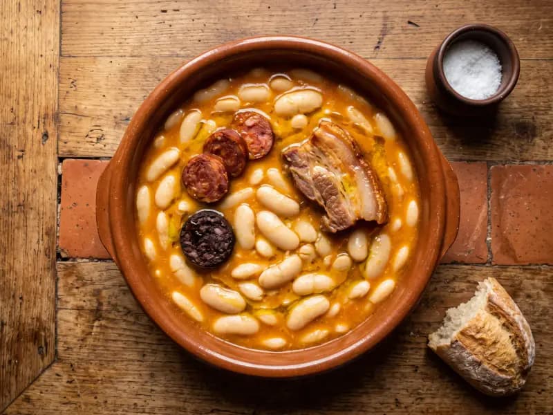 Fabada Asturiana — shot from directly overhead: big white beans stewed slowly with chorizo