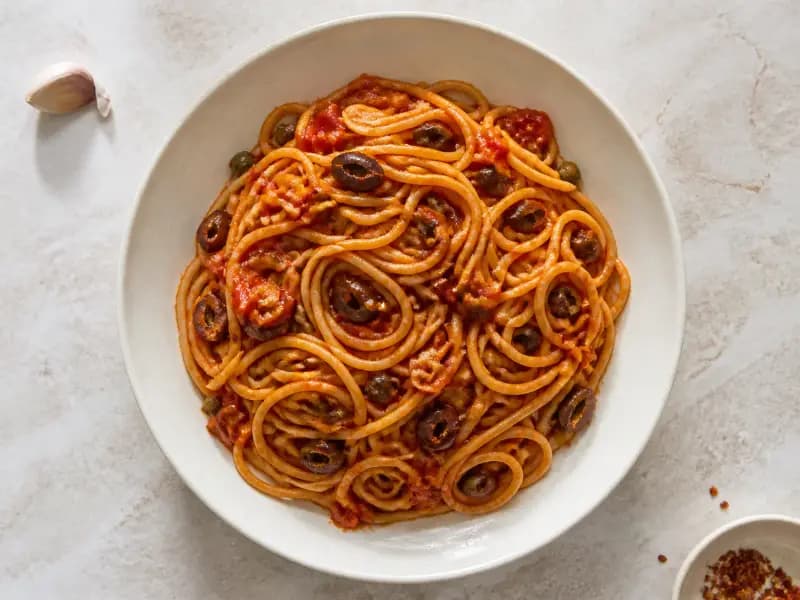 Spaghetti alla Puttanesca — shot from directly overhead: a store-cupboard sauce of anchovies