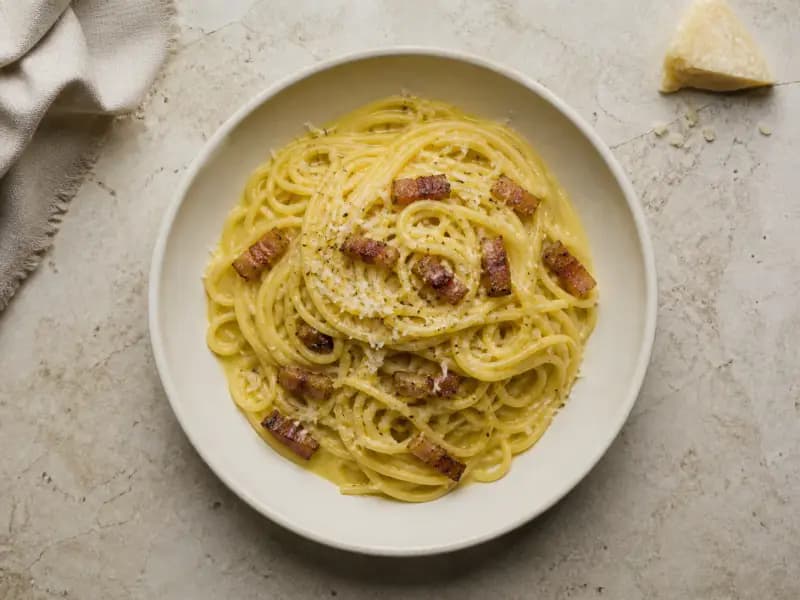 Spaghetti Carbonara — shot from directly overhead, the table surface filling the frame