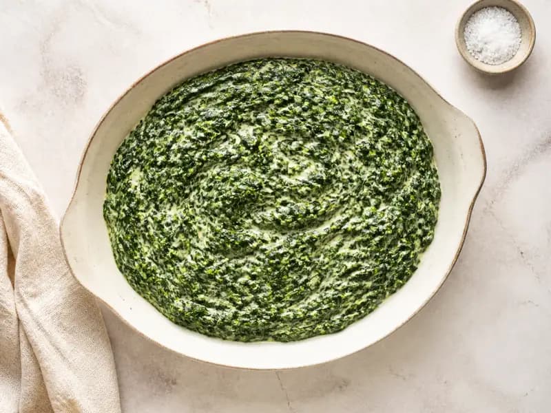 Creamed Spinach — shot from directly overhead: wilted spinach squeezed bone dry before it meets the cream