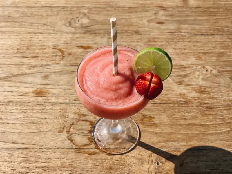 Frozen Strawberry Daiquiri — shot from directly overhead, the table surface filling the frame