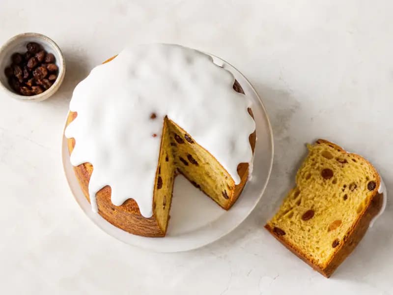 Kulich — shot from directly overhead: tall enriched Easter bread coloured with saffron and studded with raisins