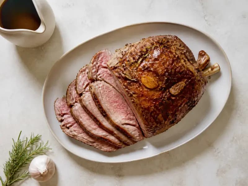 Roast Leg of Lamb with Garlic and Rosemary — shot from directly overhead: a bone-in leg studded with garlic and rosemary