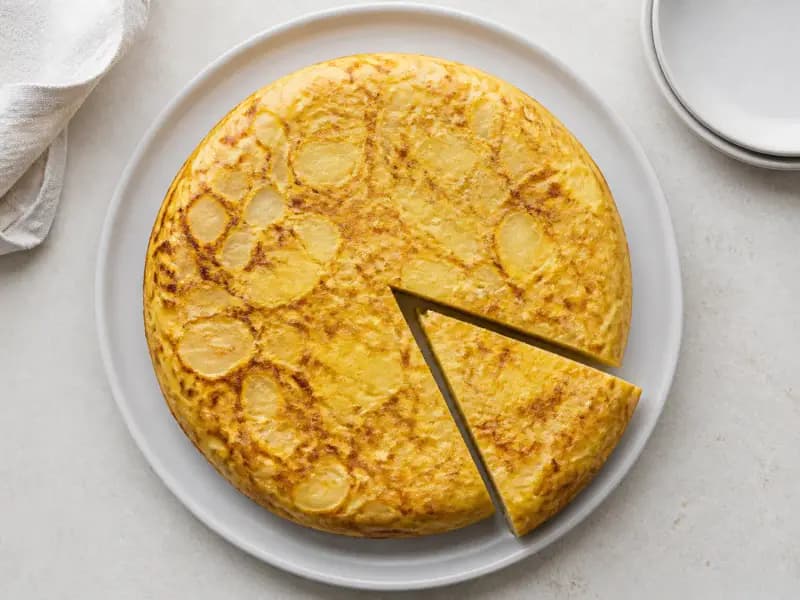 Spanish Potato Tortilla — shot from directly overhead: potatoes and onion softened slowly in olive oil