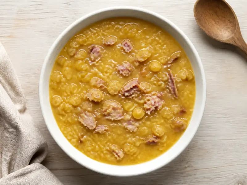 Split Pea and Ham Hock Soup — shot from directly overhead: yellow split peas simmered with a smoked ham hock until they collapse into the broth
