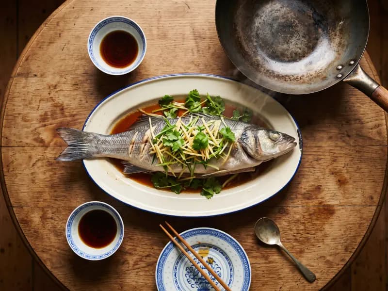 Steamed Sea Bass with Ginger and Spring Onion — shot from directly overhead: a whole fish steamed plain