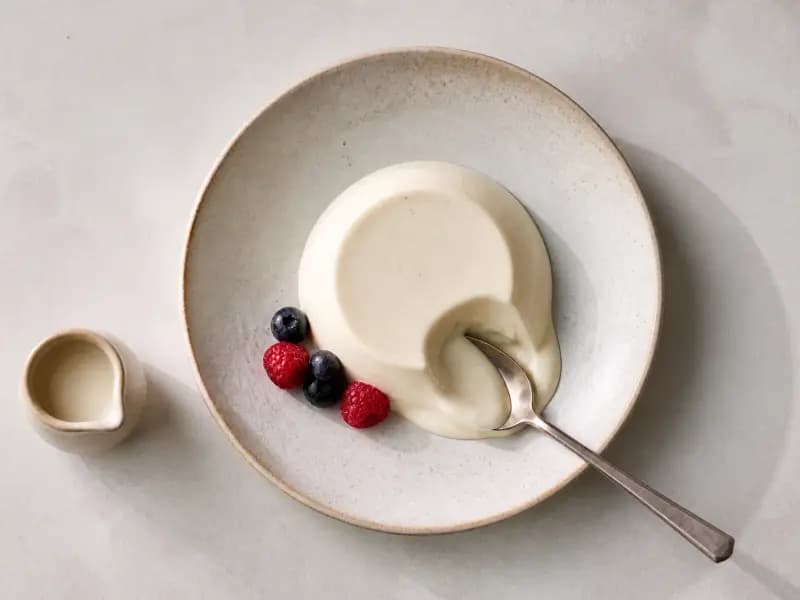 Vanilla Panna Cotta — shot from directly overhead, the table surface filling the frame